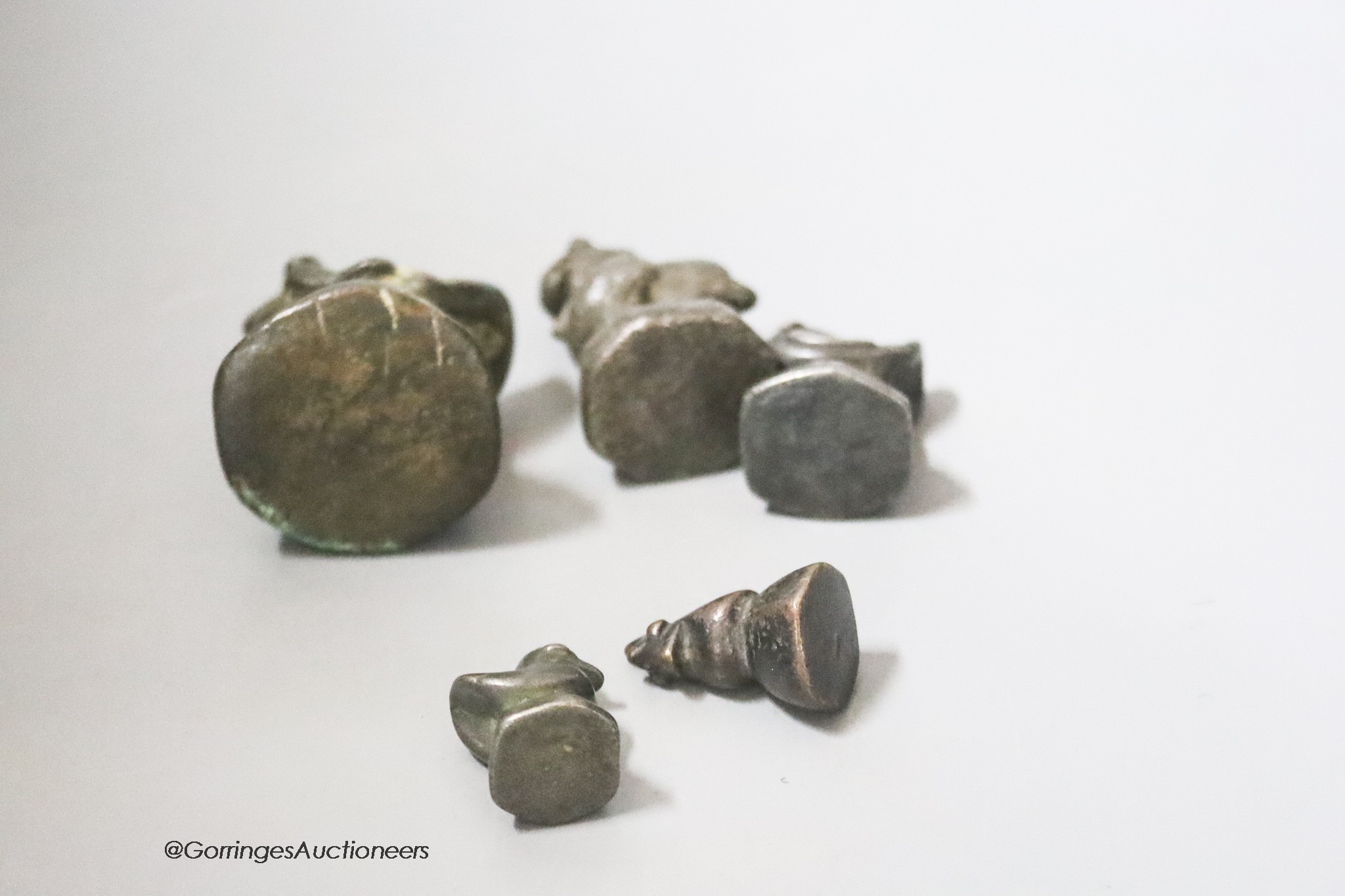 A set of five Burmese bronze opium weights, tallest 6cm